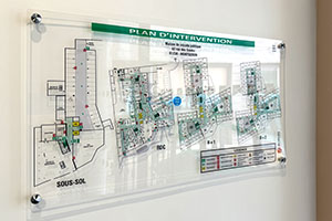 plan d'intervention sous plexiglas affiché dans un hall d'immeuble d'habitation