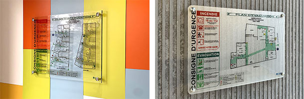 Plan d'évacuation sous plexiglas fixé sur un mur à proximité d'une circulation