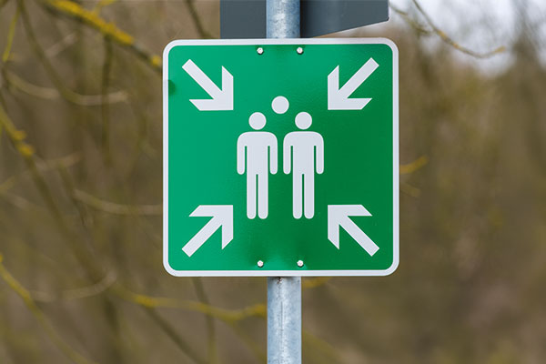 Panneau point de rassemblement E007 posé sur poteau en extérieur